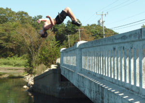 Young boy jumping off ledges is example of Kinasthlete play personality