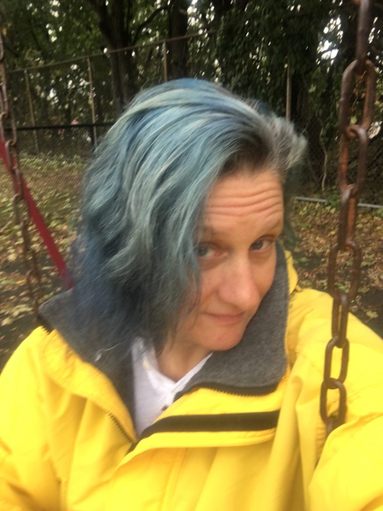 fading blue hair, wearing a yellow coat