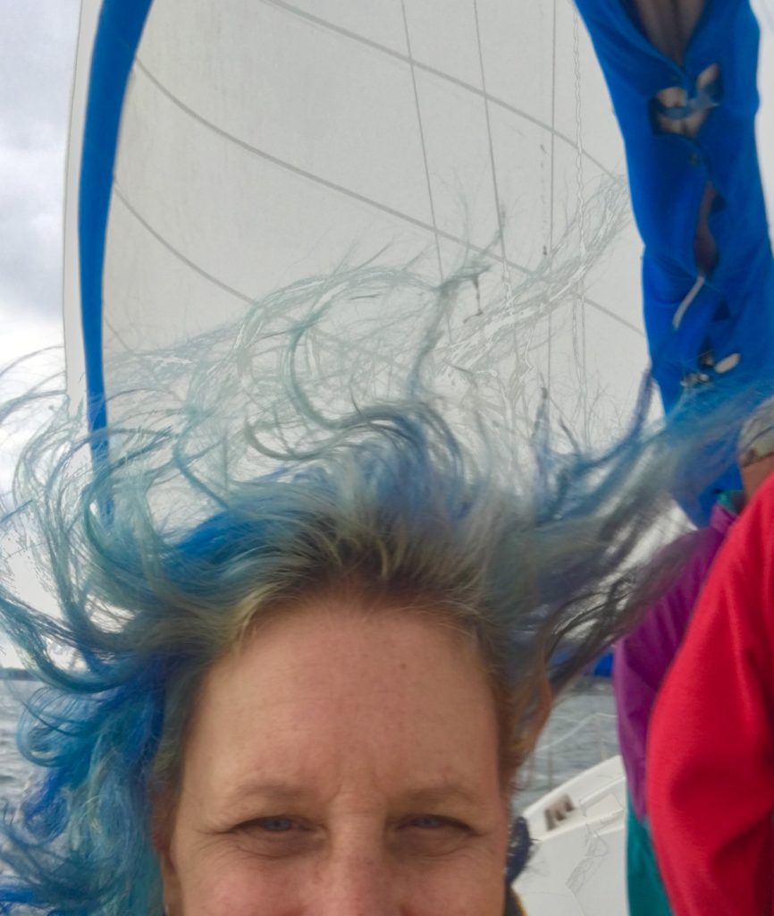 blue hair blowing in the wind on a sailboat