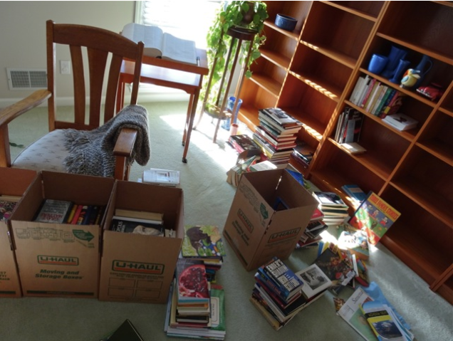 living room with books being packed off shelves and into boxes