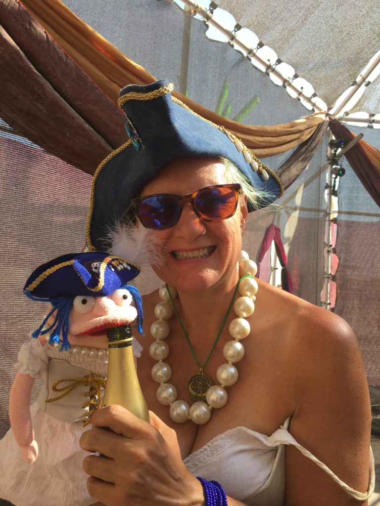 Stacey and Stacey the Pirate Puppet drinking champagne at Burning Man