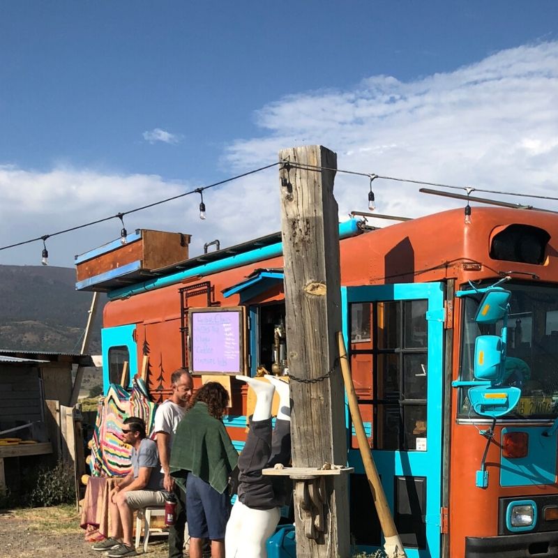 Brown and teal blue bus converted into coffee stand selling Chaga and other morning beverages