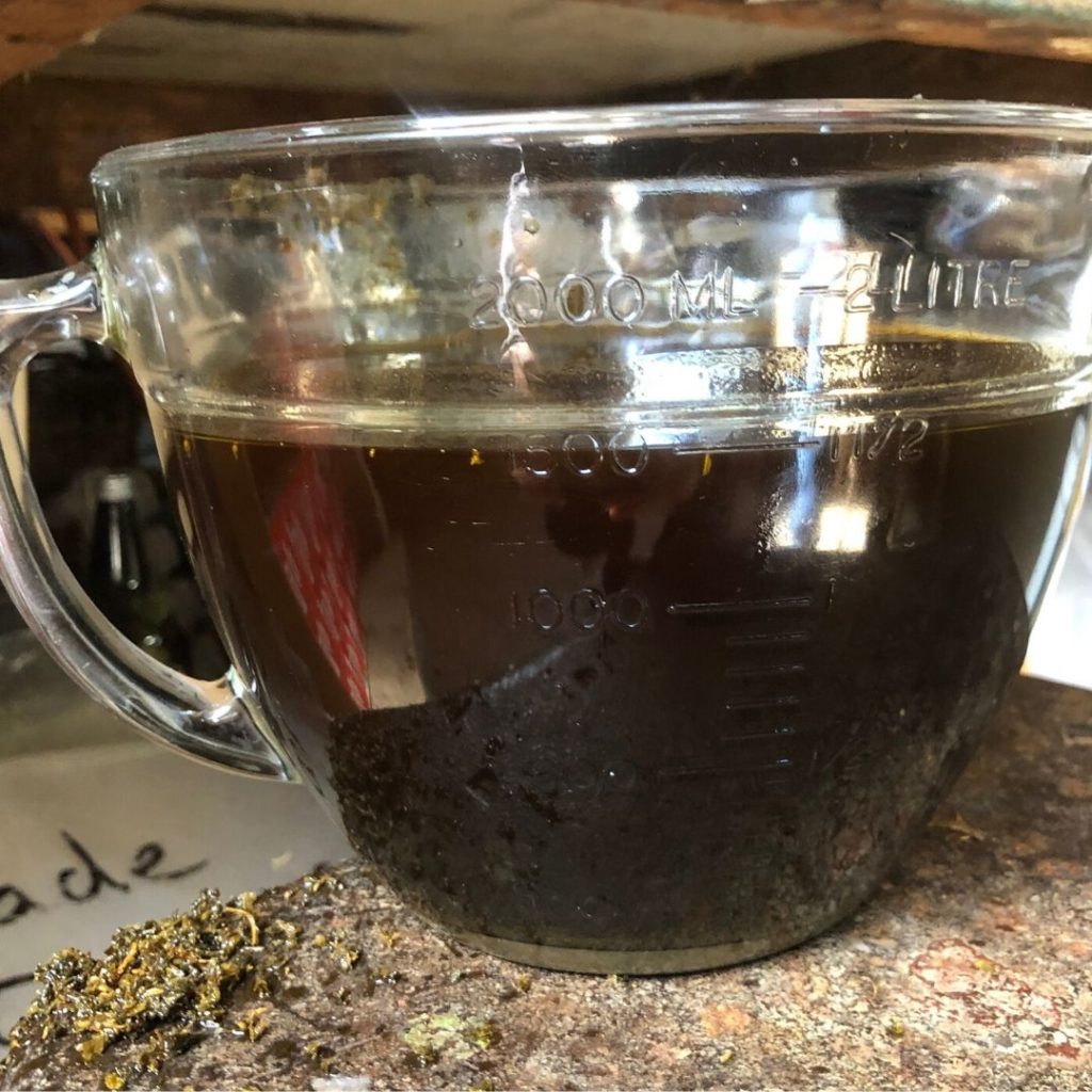 dark liquid filling glass measuring cup