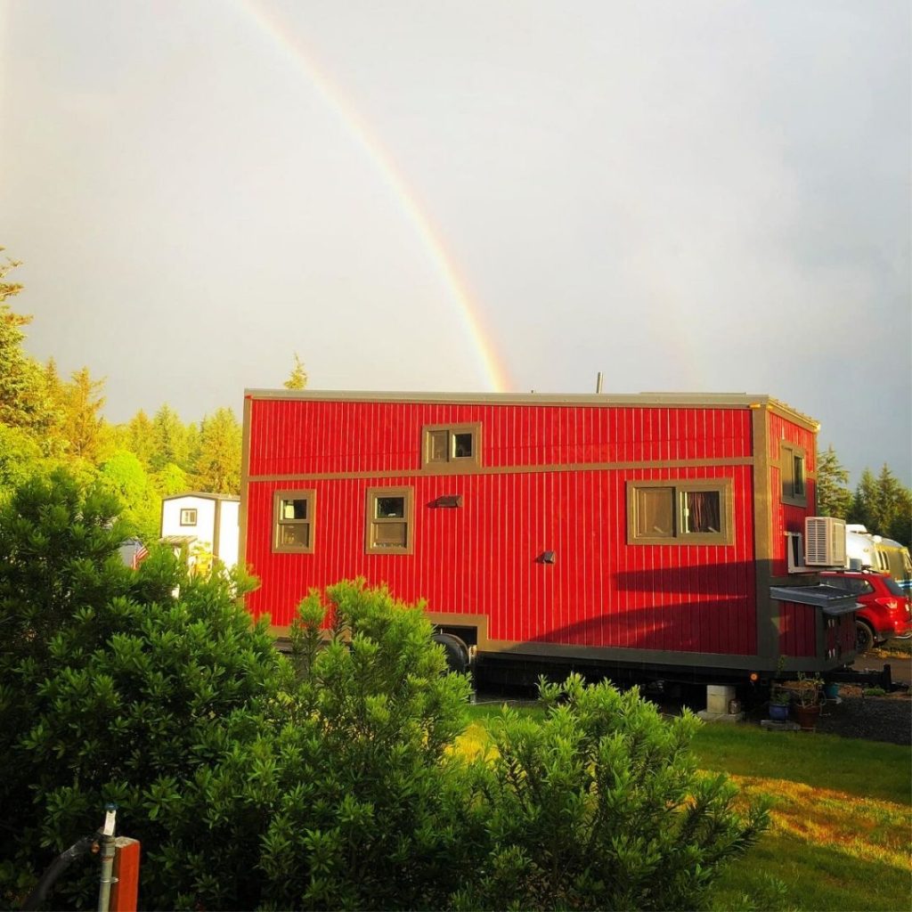 red tiny house with rainbow overhead