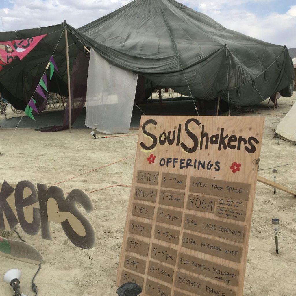 parachute tent at Burning Man with cacao ceremony on seminar listing board