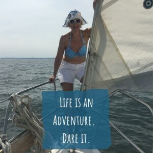 Life is an adventure. Dare it. image of Stacey on sailboat