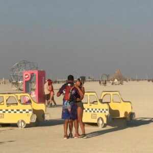 Couple salsa dancing by Adventure Taxis at Burning Man