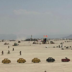 daytime view of registered art at Burning Man, with the Man in backgroung